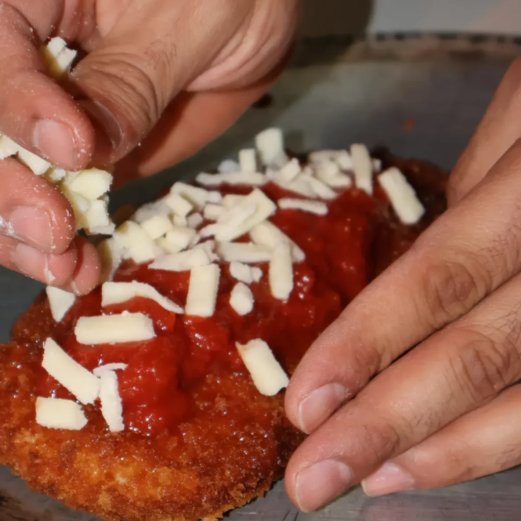 Fresh mozzarella added to a pizza base at Neighborhood Pizza and Pasta
